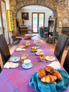 a table with croissants and breads on it at Mas la Marchette in Oms