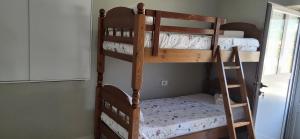 two bunk beds in a room with a ladder at Jon rooms in Himare