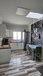 een keuken met een tafel en stoelen en een koelkast bij Apartamentos GARAKOTA in Telde