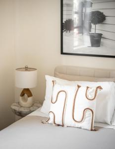 un letto bianco con cuscino bianco e lampada di Cozy and Modern One-Bedroom Apartment a New York