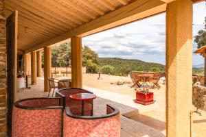 a porch with two chairs and a table with a view at Mas la Marchette in Oms