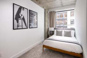 a bedroom with a bed and two pictures on the wall at Stylish Penthouse with Ceiling to Floor Windows in New York