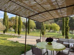- une table avec un vase de fleurs sur la terrasse dans l'établissement Maison Campagne Aixoise, à Éguilles
