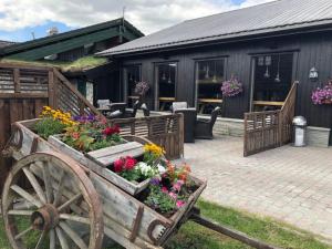 a wooden cart filled with flowers in front of a building at Spidsbergseter Resort Rondane in Venabygd