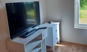 una TV seduta sopra un comò bianco di Réved(ez) a Szigetmonostor