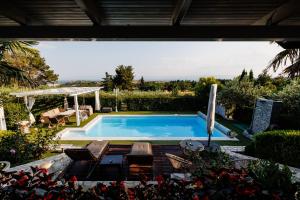 a swimming pool in a yard with a table and chairs at Hacienda Verde in Serres