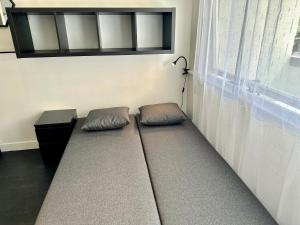 eine Couch mit zwei Kissen neben einem Fenster in der Unterkunft Happy Studio terrace in Schiltigheim