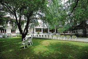 a row of white chairs sitting in a park at Hotel Maria Nella in Bardineto