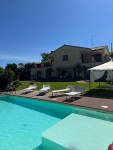 una piscina con sillas y una sombrilla junto a una casa en Villa del Sole, en Valverde