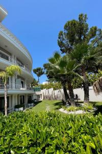 a building with trees and bushes in front of it at As Hotel Cesme in Çeşme
