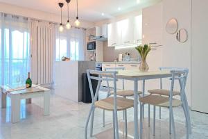 una cocina con mesa y sillas y una botella de vino en Wonderful Renovated apartment with Terrace and Parking - Benakey, en Le Cannet