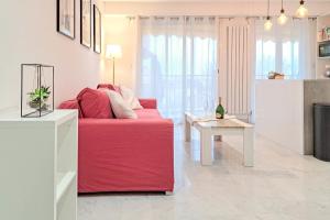 sala de estar con sofá rojo y mesa en Wonderful Renovated apartment with Terrace and Parking - Benakey, en Le Cannet