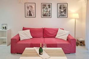 un sofá rojo en la sala de estar con una botella de vino en Wonderful Renovated apartment with Terrace and Parking - Benakey, en Le Cannet