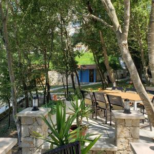 a patio with chairs and a table and trees at Green Hill Apartments in Ulcinj