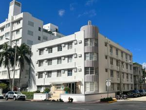 a large white building with cars parked in front of it at Suite Love in Miami Beach
