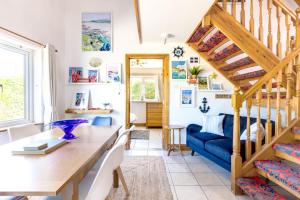 a living room with a staircase and a blue couch at Baywatch Sands in Wadebridge