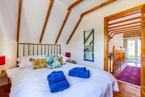 a bedroom with a white bed with blue towels on it at Baywatch Sands in Wadebridge