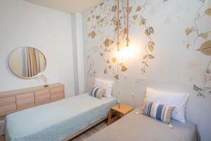 Habitación pequeña con 2 camas y espejo. en Topos Maisonettes by RentalsPro - Kalives Halkidiki, en Kalivia Poligirou