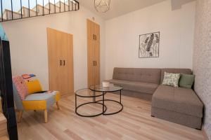 uma sala de estar com um sofá e uma mesa em Topos Maisonettes by RentalsPro - Kalives Halkidiki em Kalivia Poligirou