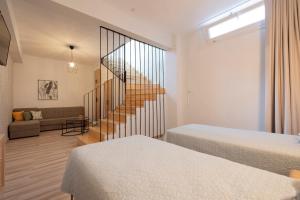 Habitación con 2 camas y escalera. en Topos Maisonettes by RentalsPro - Kalives Halkidiki, en Kalivia Poligirou