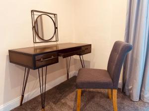 a dressing table with a mirror and a chair at The Oaks Hotel in Alnwick