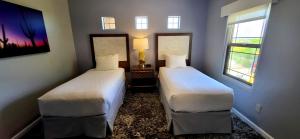 two beds in a room with two windows at WorldMark Rancho Vistoso in Oro Valley