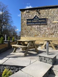 a wooden picnic table in front of a stone building at The Oaks Hotel in Alnwick