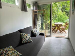 sala de estar con sofá y puerta corredera de cristal en Maison calme et verdure, en Saint-Cannat