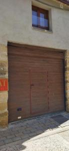 una gran puerta de garaje de madera en el lateral de un edificio en Apartamentos Lorione, en Olite