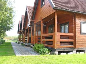 a large wooden building with a pathway in front of it at Domki u Jacola Gąski in Gąski