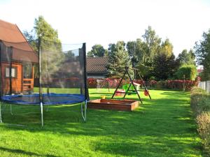 a yard with two swings and a playground at Domki u Jacola Gąski in Gąski