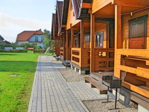 a row of wooden buildings with a walkway in front at Domki u Jacola Gąski in Gąski