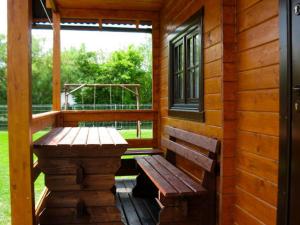 a wooden bench sitting on the porch of a cabin at Domki u Jacola Gąski in Gąski +18 photos