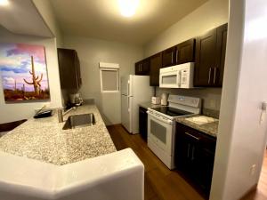 a kitchen with black cabinets and white appliances at WorldMark Rancho Vistoso in Oro Valley