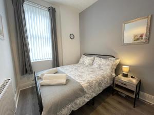 a small bedroom with a bed and a window at Belford Apartment, Close to Tynemouth in Tynemouth