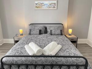 a bedroom with a bed with pillows and two tables at Belford Apartment, Close to Tynemouth in Tynemouth