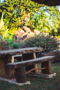 um banco de madeira sentado em frente a um jardim em Irová Apart Hotel em Posadas