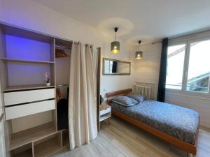 ein Schlafzimmer mit einem Bett und einem großen Fenster in der Unterkunft F2 Résidence Eurotel n°5 avec vue sur le Cher, Centre - Ville in Montluçon