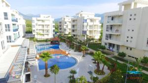 an apartment complex with a swimming pool and palm trees at Apartman Martini in Orikum