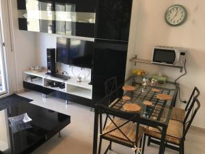 a dining room with a table and a clock on the wall at Apartman Martini in Orikum