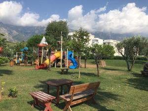 a park with a playground with a slide and a bench at Apartman Martini in Orikum