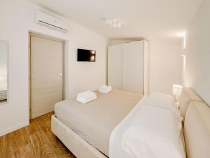 a white bedroom with a bed and a mirror at Villa Angelica - Casa Vacanze in Reggio Calabria