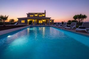 ein Pool mit Stühlen und ein Haus im Hintergrund in der Unterkunft Villa Paradise by Algarve Vacation in Lagoa