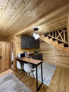eine Küche mit einem Tisch und 2 Stühlen in einem Zimmer in der Unterkunft WooD_House_Issyk-Kul in Bosteri