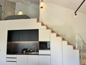 a kitchen with white cabinets and a staircase at Morgado da Granja in Aveiro