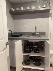 a kitchen with a sink and pots and pans at Fully Furnished CozyTwo Bedroom in Winnipeg