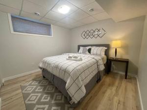 a bedroom with a bed and a lamp and a window at Fully Furnished CozyTwo Bedroom in Winnipeg