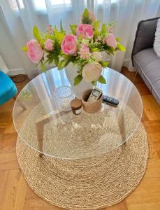 a glass coffee table with a vase of flowers on it at Nice, 58 M2 ! superbe appartement climatisé, 3 couchages, proche de la promenade des Anglais et de la Gare ! in Nice