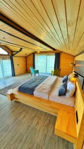 a large bed in a room with a wooden ceiling at Panorama Otel in Uzungol
