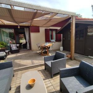 a patio with chairs and a table and an umbrella at Blue Ocean in Moliets-et-Maa